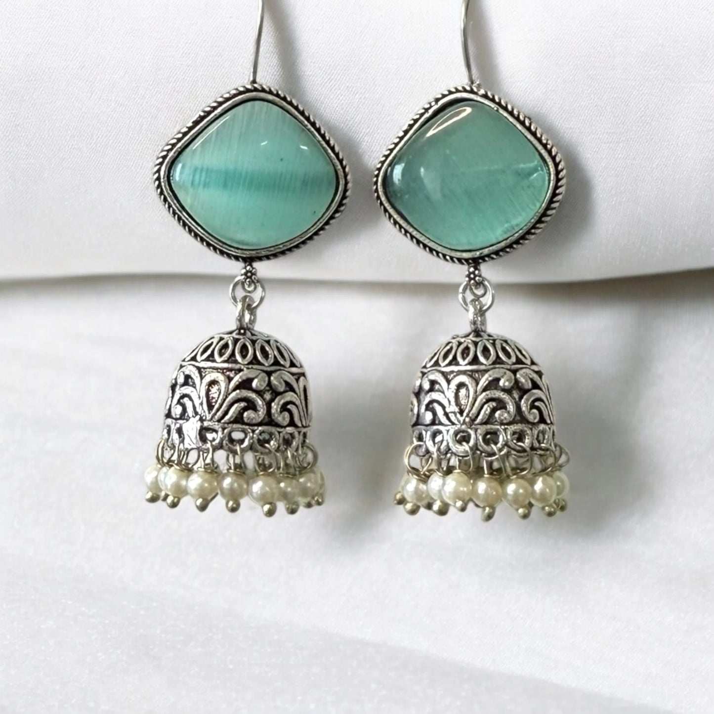 Elegant Green Stone Jhumka Earrings with Intricate Silver Detailing