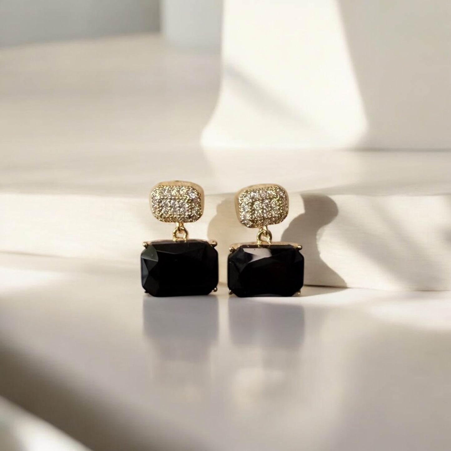 Black and gold crystal drop earrings with a rectangular gemstone