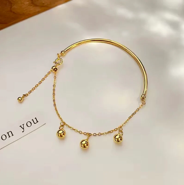 Gold Bangle with Hanging Ball Charms – Elegant and Modern Design