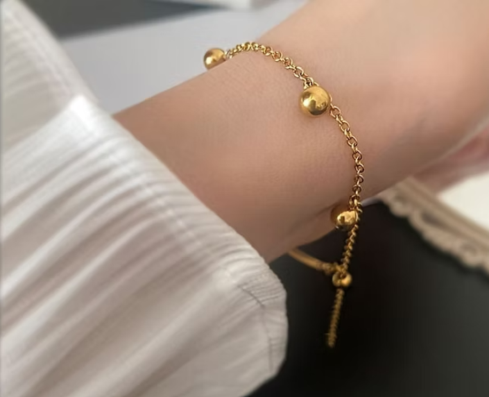 Gold Bangle with Hanging Ball Charms – Elegant and Modern Design