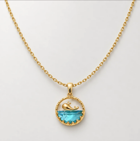 Ocean whale pendant necklace with blue crystal on a gold chain