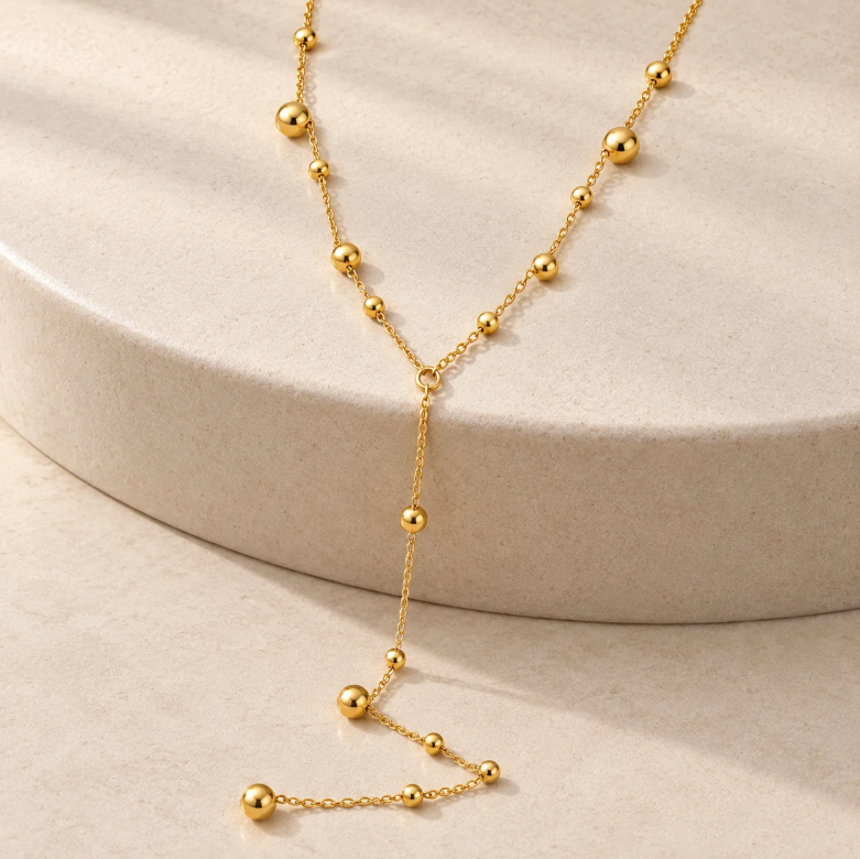 Gold beaded lariat necklace with a Y-shaped drop