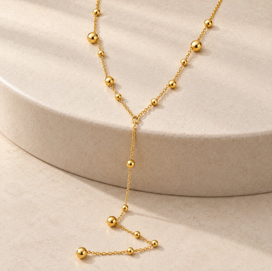 Gold beaded lariat necklace with a Y-shaped drop